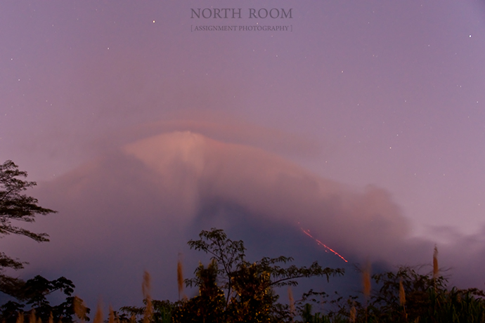 Arenal at dusk.  You can see the lava running down the right-hand side below the cloud, and the ash above